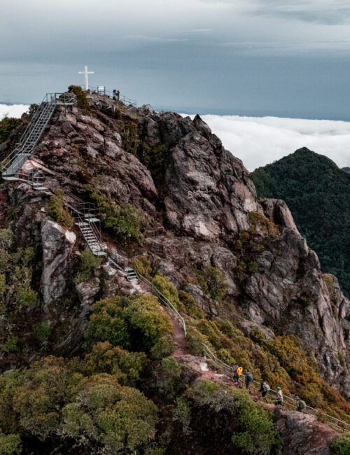 Vista aérea de la cima del Volcán Barú en Panamá con la cruz y senderistas entre las montañas.