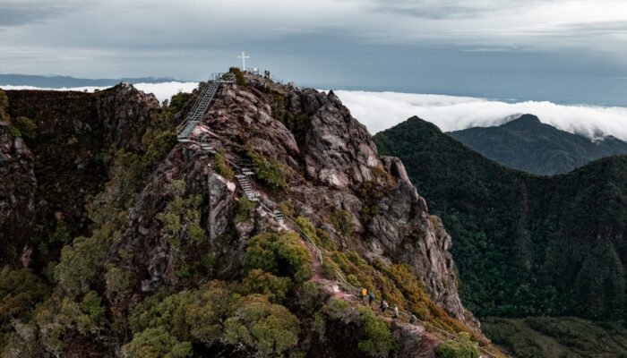 Vista aérea de la cima del Volcán Barú en Panamá con la cruz y senderistas entre las montañas.