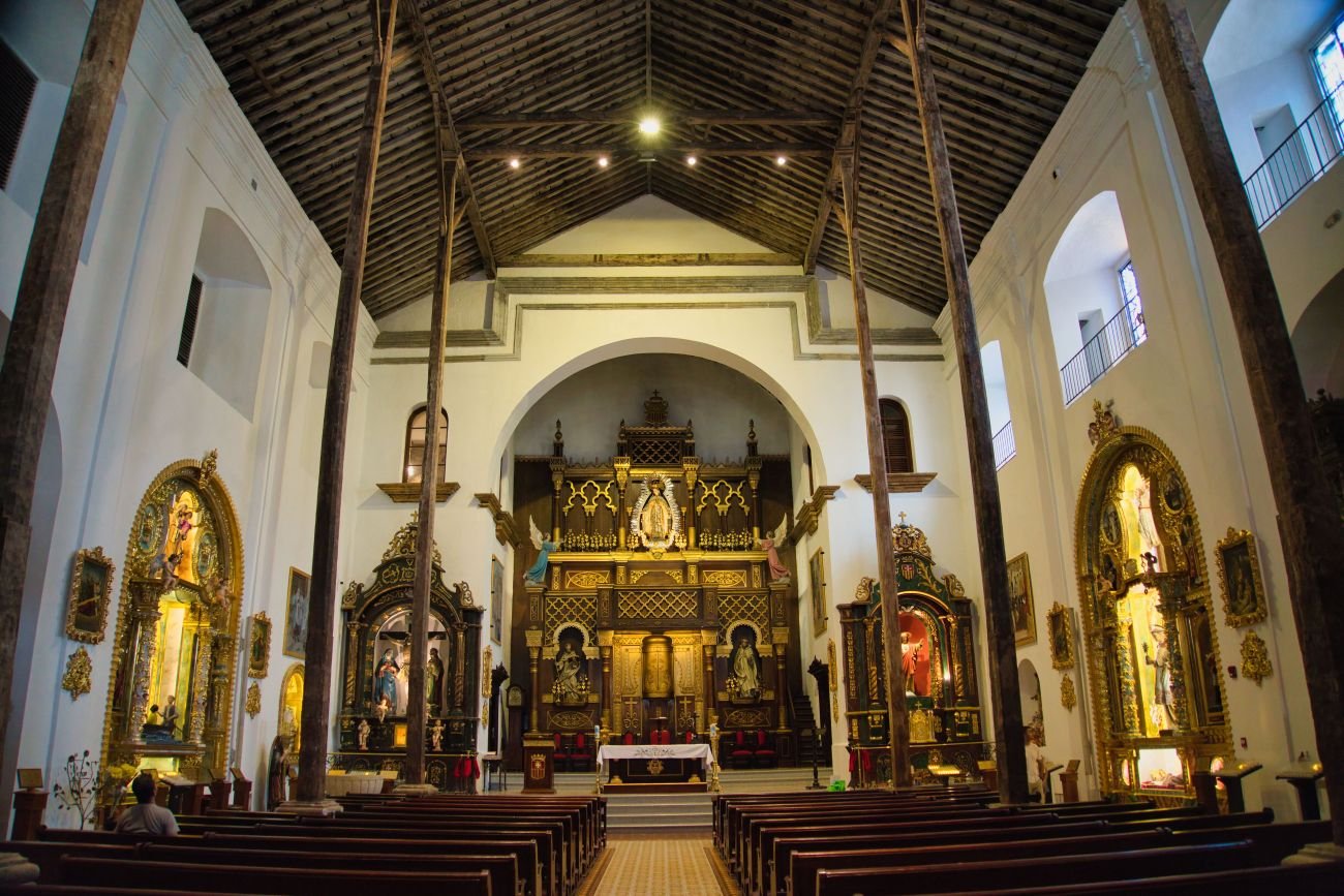 Interior de la Iglesia Nuestra Señora de La Merced en el Casco Antiguo, con retablos coloniales y techo de madera.