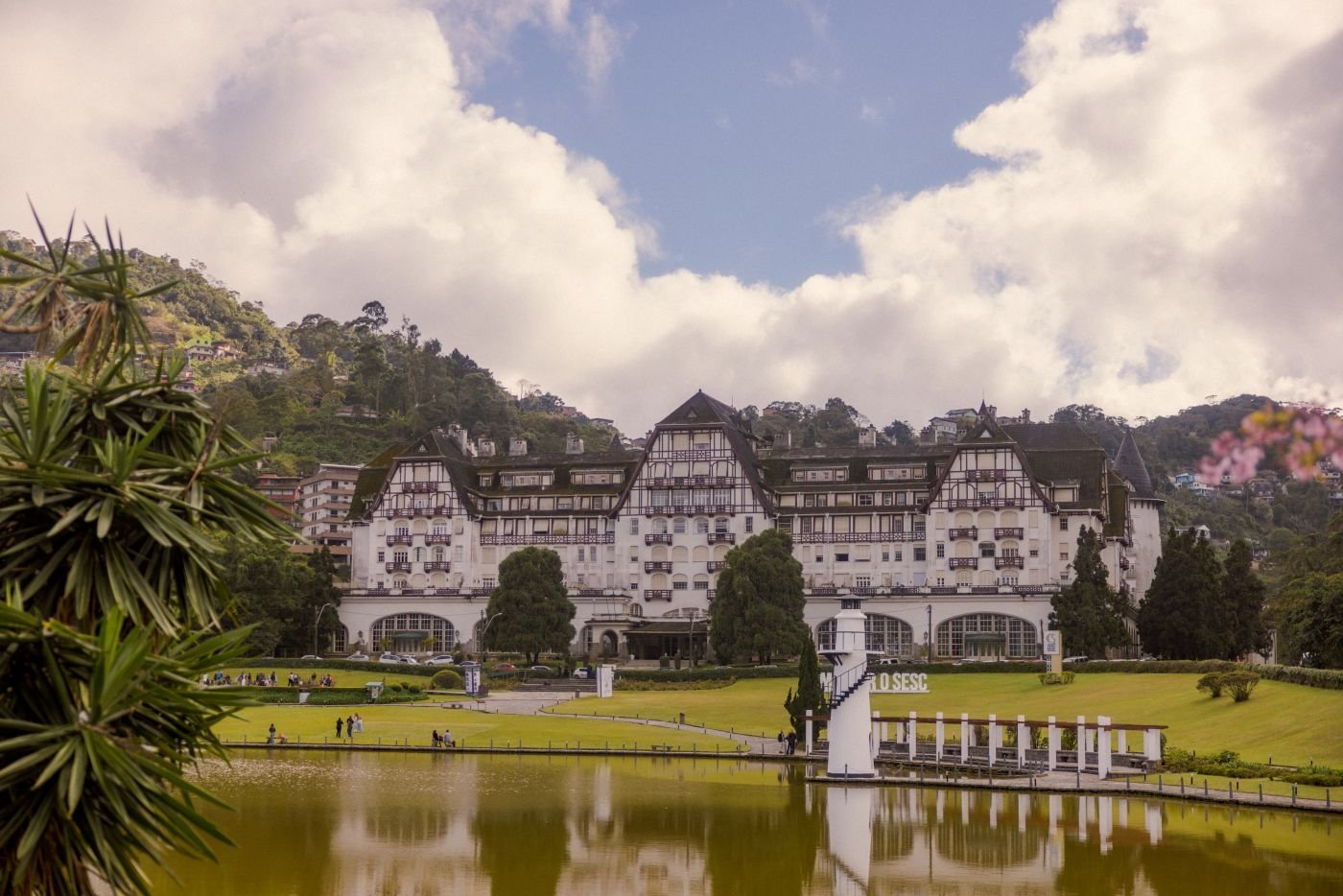 Vista del Palacio Quitandinha en Petrópolis, Brasil, rodeado de montañas y reflejado en el lago, símbolo del encanto imperial cercano a Río de Janeiro.
