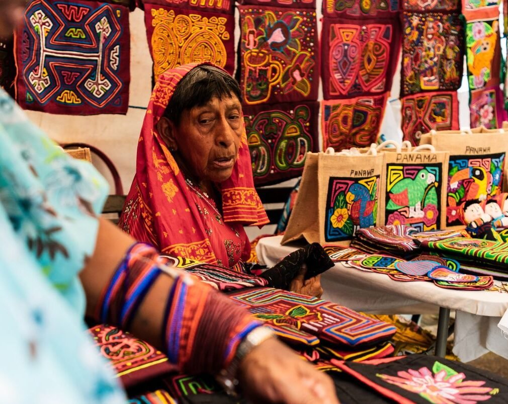 Artesanas guna vendiendo coloridas molas hechas a mano en un mercado de Panamá.