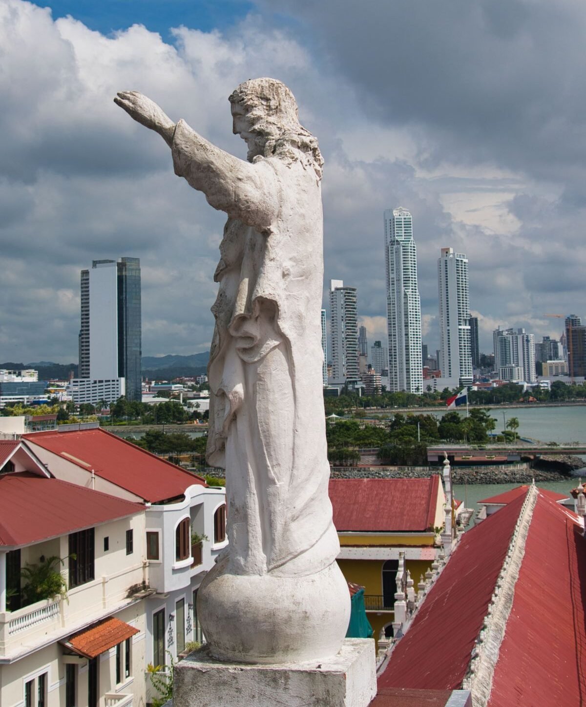Estatua del Cristo en la Iglesia San Francisco de Asís, con vista al skyline moderno de Ciudad de Panamá desde el Casco Antiguo.